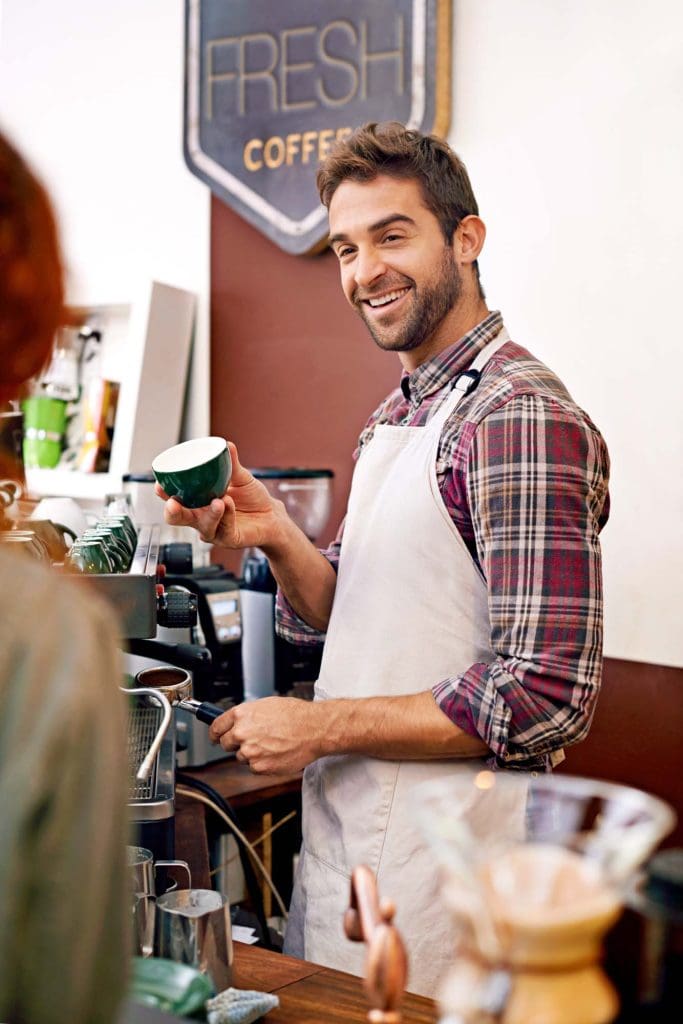 Cafe owner making coffee for a customer